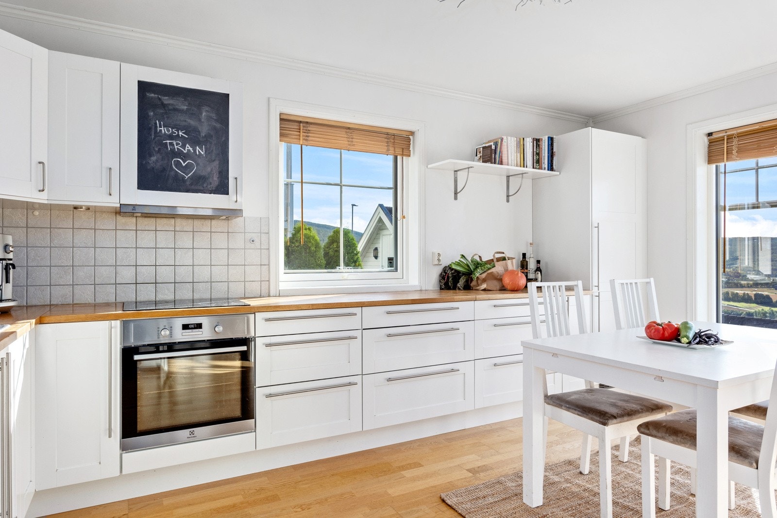 Det er fliser over benk og arbeidsplass foran vinduet. Galleribilde