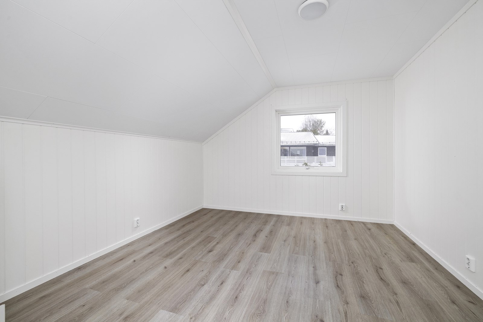Stort soverom med lysmalte vegger og laminat på gulv. Galleribilde