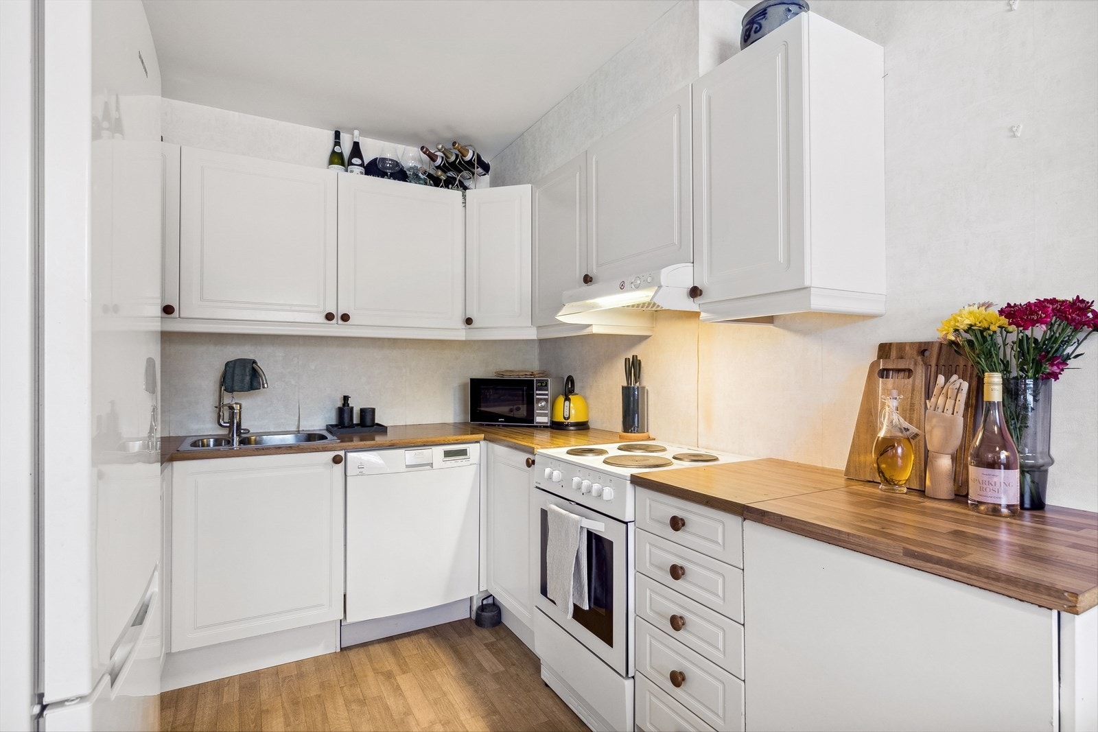 Praktisk kjøkken med hvit profilert innredning. Galleribilde