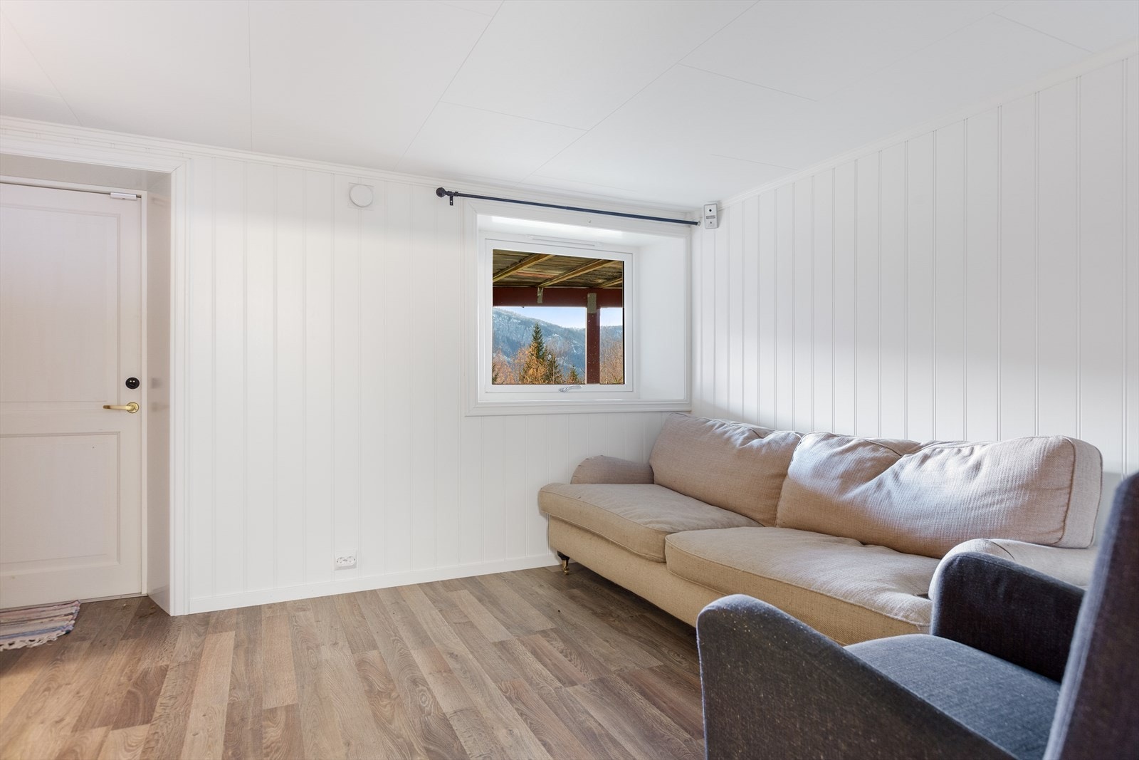 Stue i kjeller med plass til en sofagruppe. Egen utgang ut. Galleribilde