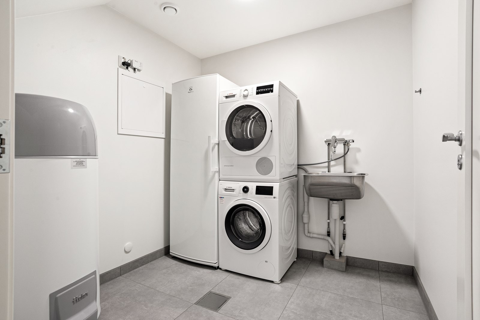 Vegg i vegg med badet ligger et separat og praktisk vaskerom. Rommet har fliser på gulv med sokkelflis og malte veggflater. Det er videre utstyrt med utslagsvask med ett- greps blandebatteri og opplegg for vaskemaskin. Galleribilde
