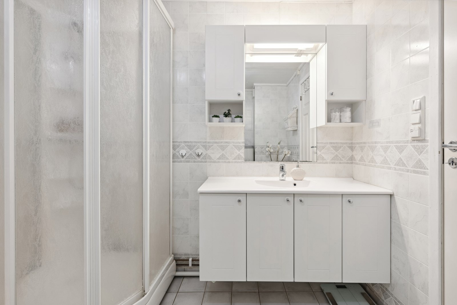 Badet inneholder baderomsinnredning, dusjkabinett og gulvstående klosett. Galleribilde