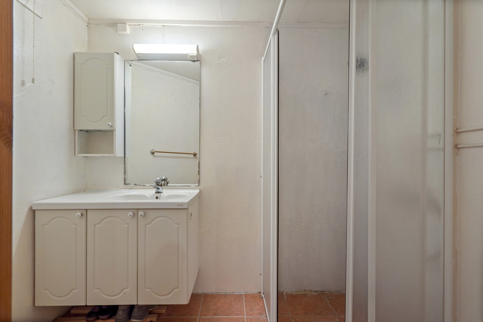Badet har innredning med nedfelt servant, overskap og speil på vegg. Galleribilde