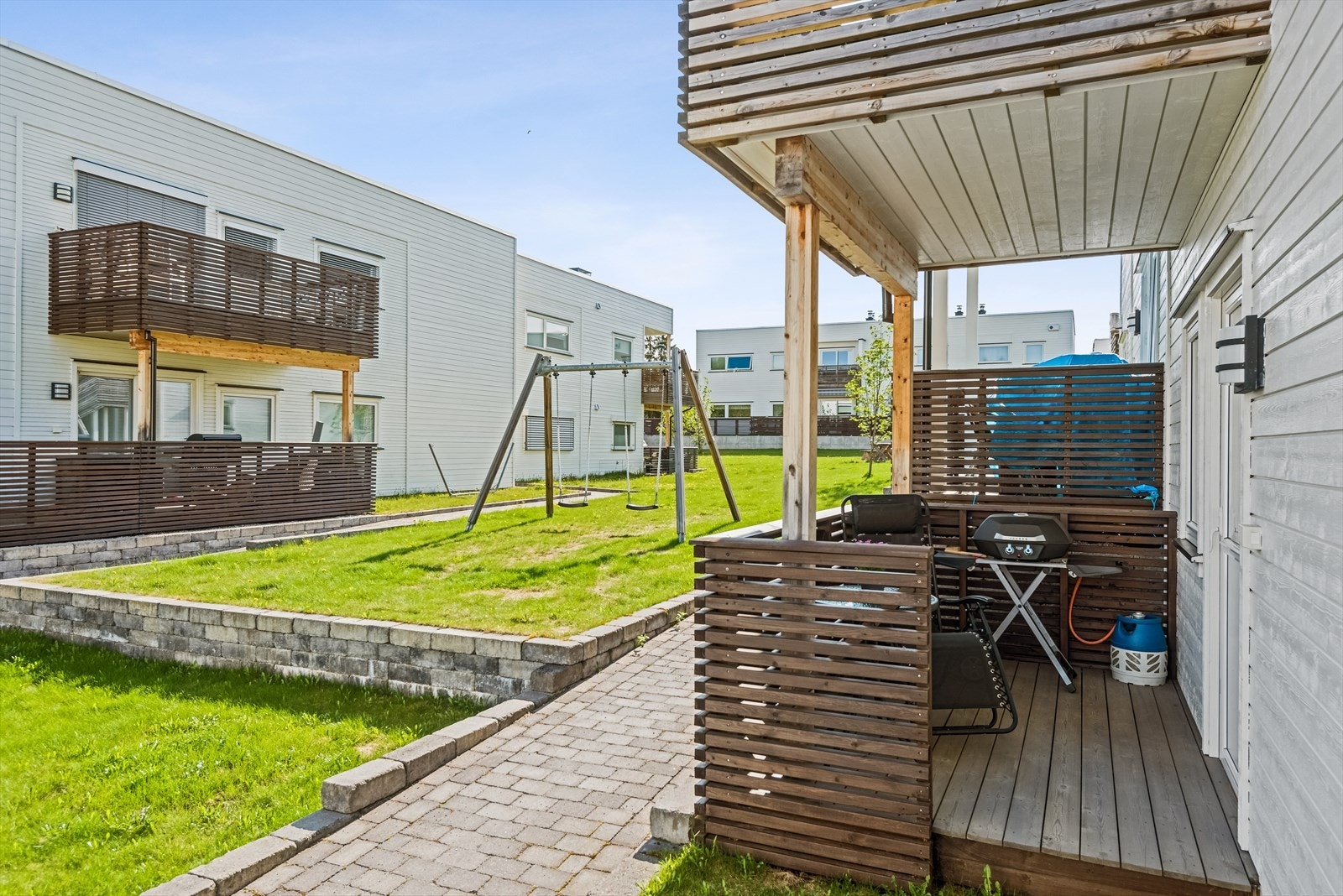 Terrassen som har adkomst fra soverommet. Utenfor leiligheten er det flotte uteområder med benker og lekeplasser. Galleribilde