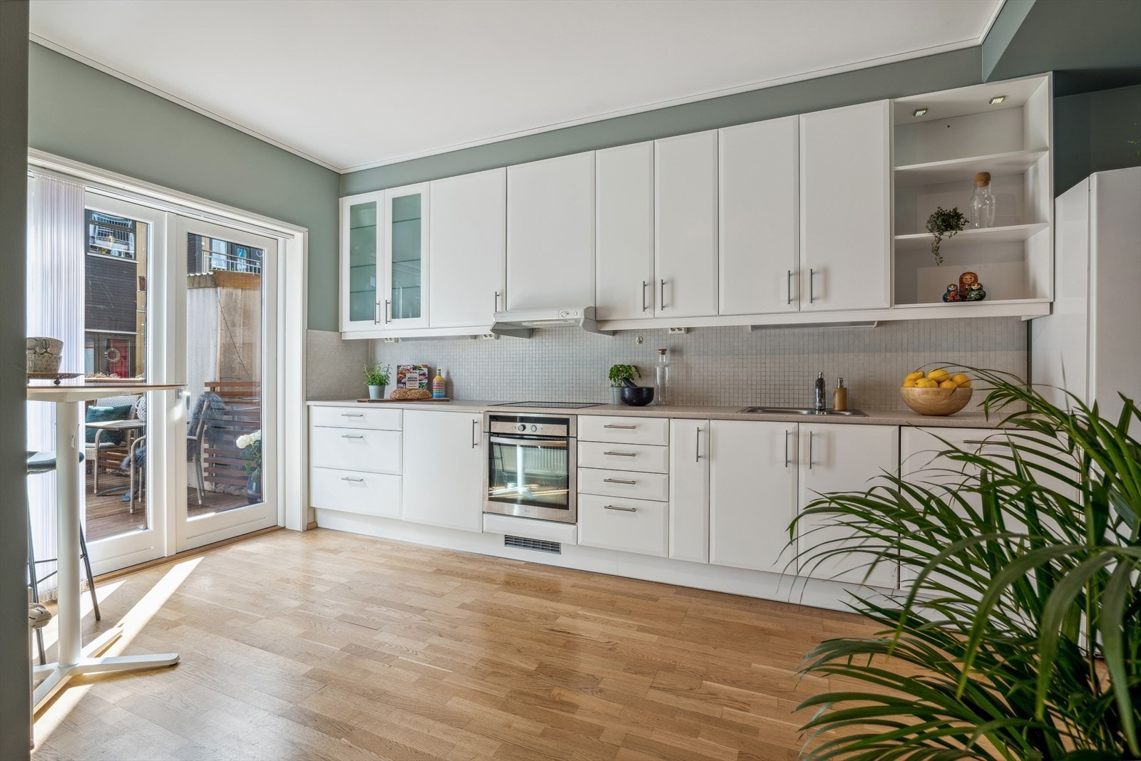 Pent kjøkken med en hyggelig spiseplass og verandadør ut til terrassen hvor man kan nyte morgen- og formiddagssolen. Galleribilde