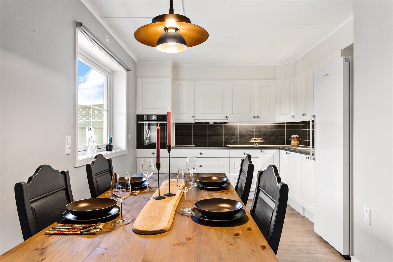 Kjøkkeninnredningen har en delikat kombinasjon av profilerte fronter og laminatbenkeplate. Mellom over- og underskap er det praktiske kitchenboard plater. Galleribilde