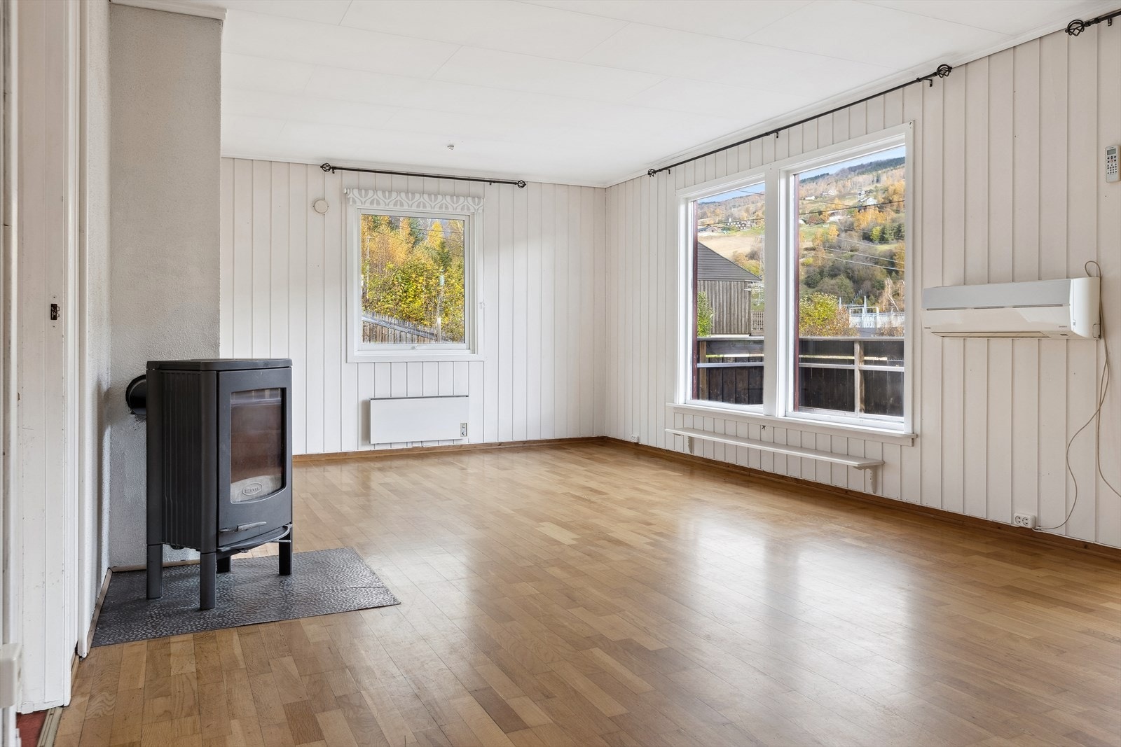 Romslig og lys stue med peisovn og varmepumpe for oppvarming. Galleribilde