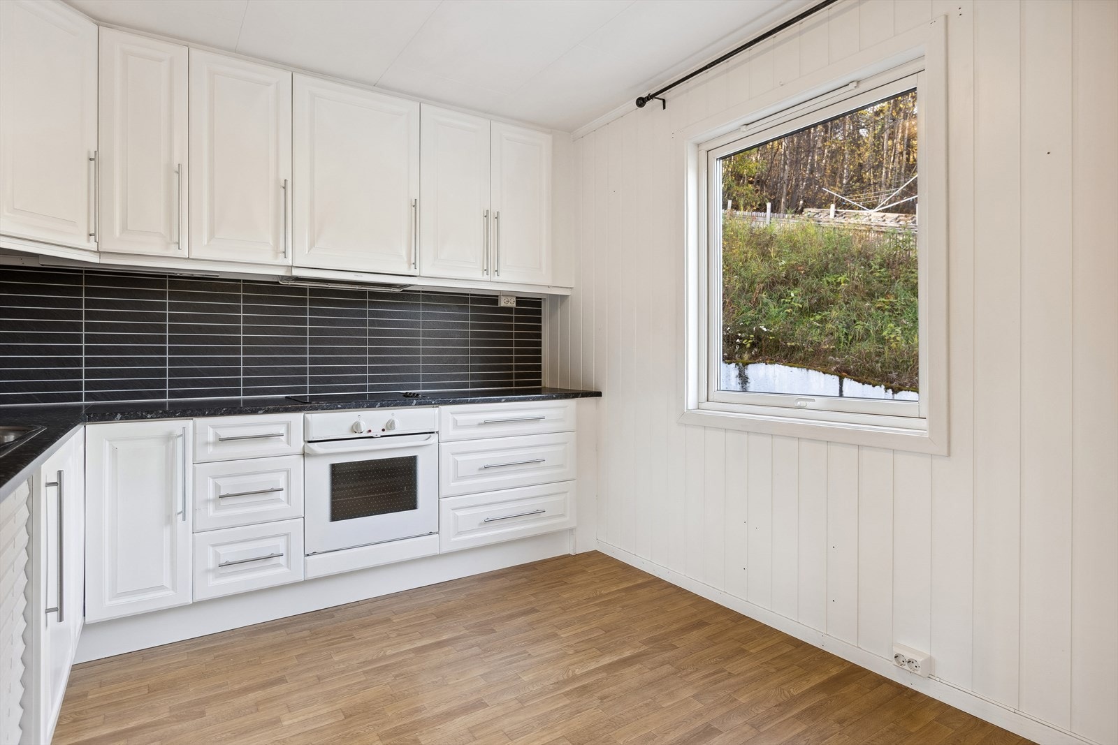 Kjøkkenet har innredning med profilerte fronter. Benkeplaten er av laminat. Galleribilde