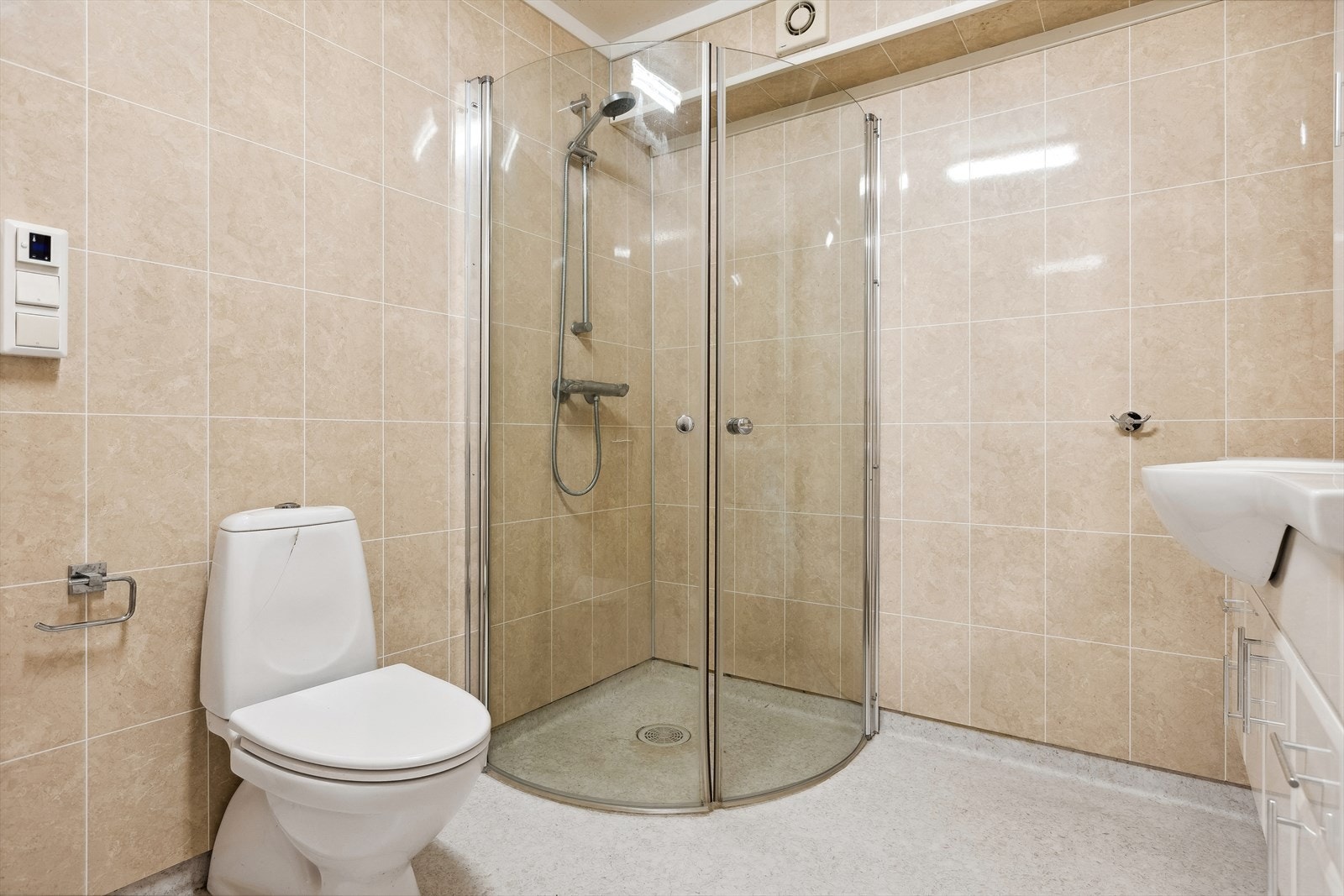 Nyere bad i underetasjen bestående av gulvbelegg med oppbrett, våtromsplater på vegger og plater i himling. Det er elektriske varmekabler i gulv. Galleribilde