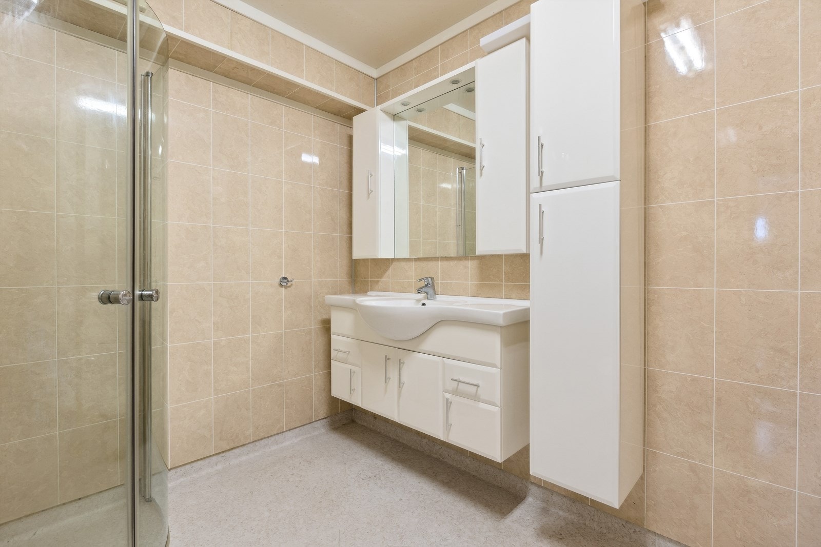 Rommet har dusjvegger, toalett, baderomsinnredning med servant, opplegg for vaskemaskin, stålkum. Galleribilde