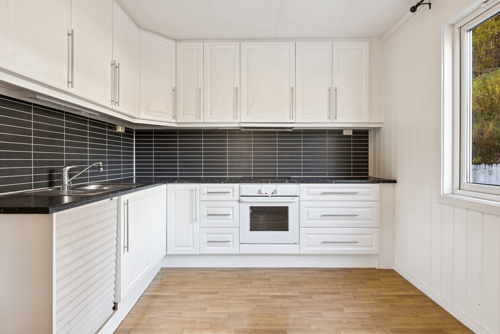 Lyst og romslig kjøkken med plass til kjøkkenbord og stoler. Galleribilde