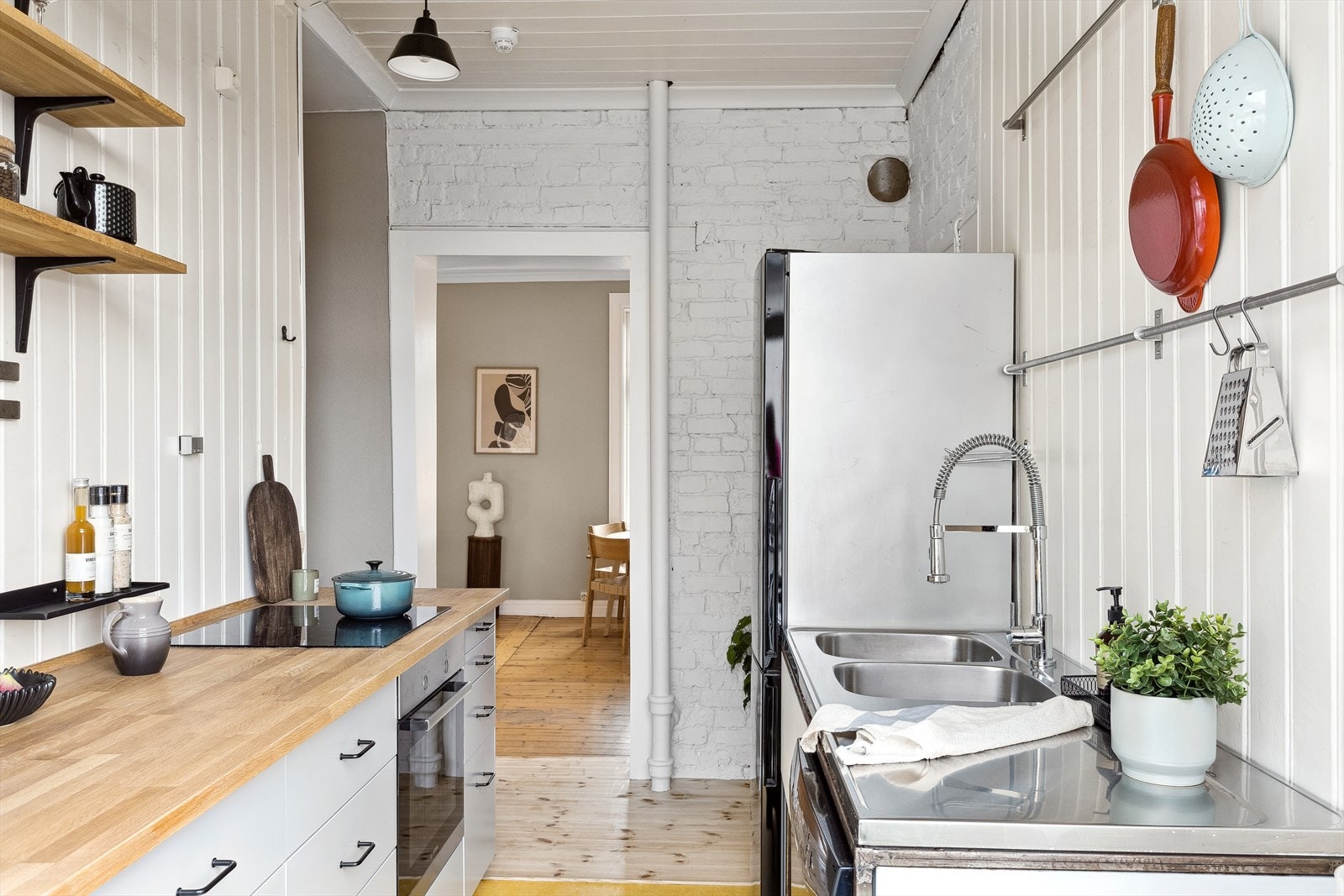 Kjøkkeninnredningen består av slette, lakkerte fronter og heltre benkeplate i eik med dobbel oppvaskkum med benkebeslag. Galleribilde