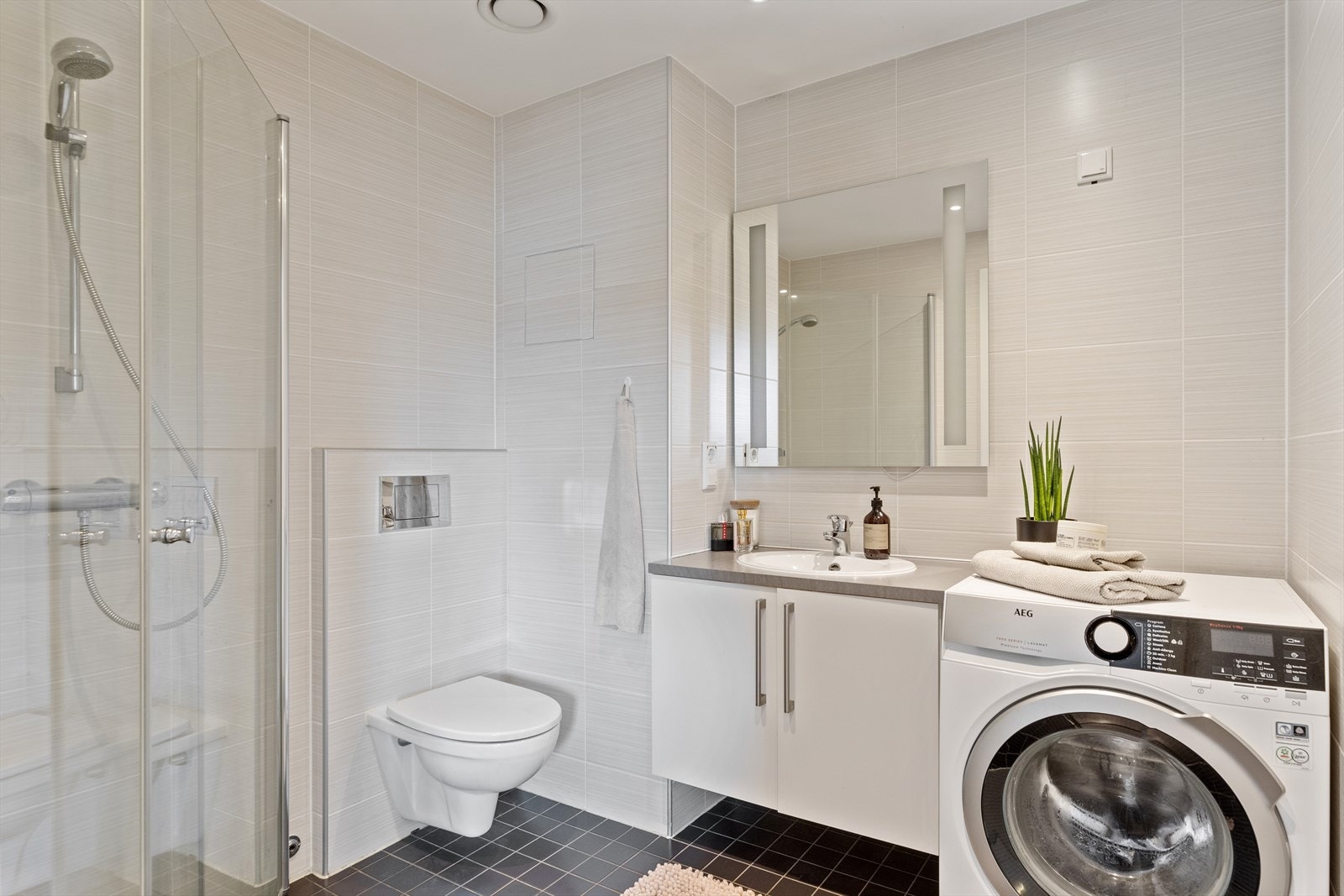 Ved stuen har leiligheten et flott bad med flislagte overflater. Galleribilde