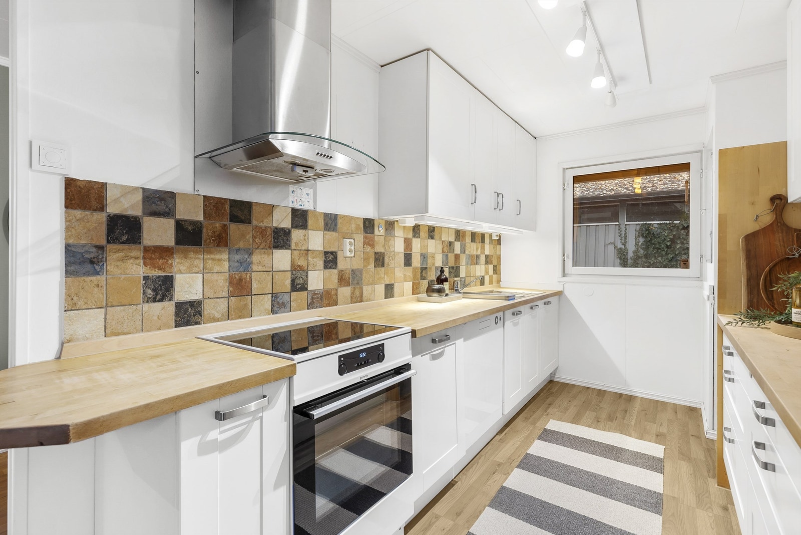 Lys kjøkkeninnredning med laminat benkeplate. Noe slitasje på benkeplate og fronter. Galleribilde