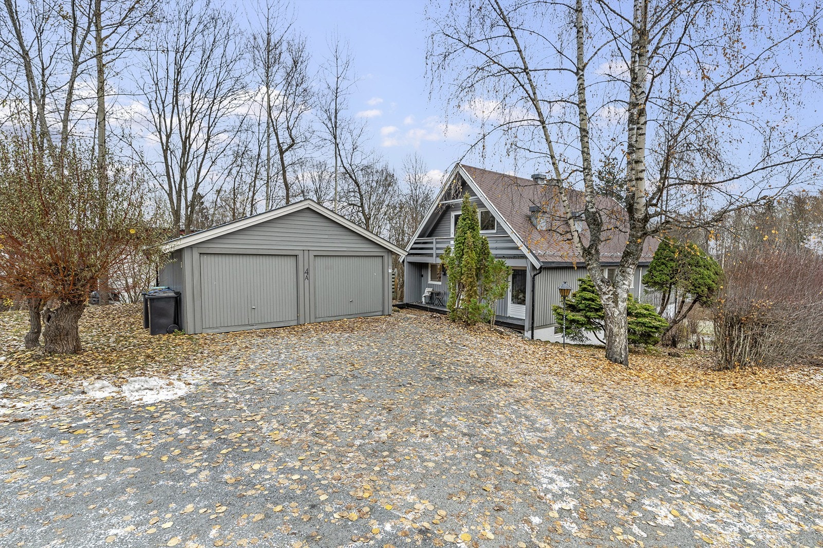 Asfaltert gårdsplass. Dobbelgarasje med to vippeporter. Galleribilde