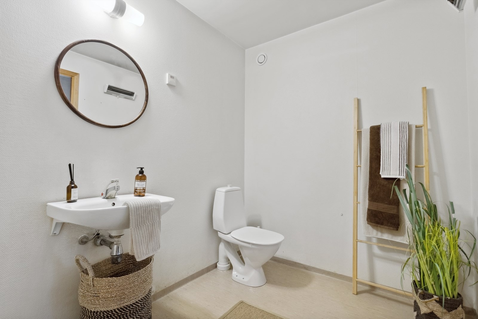 Baderommet er ca 5,2 m² og har gulvbelegg med oppbrett på vegg, malt strie på vegger og malt betonghimling. Gulvmontert toalett, vegghengt servant, åpen dusjsone. Galleribilde