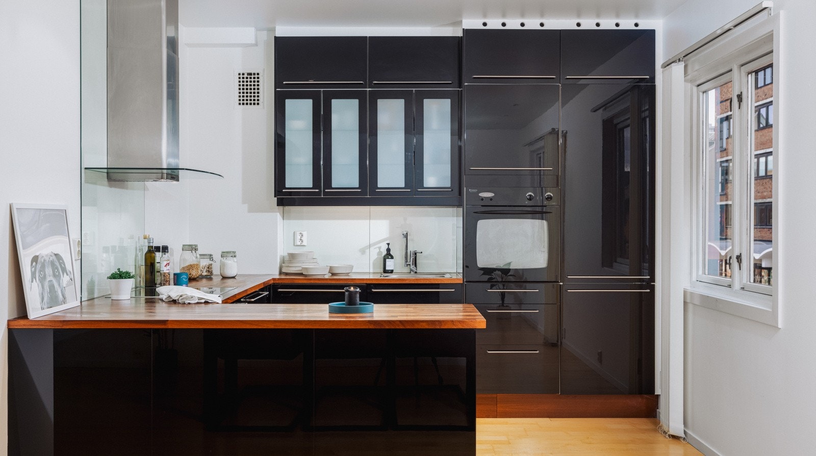 Fint kjøkken med slette svarte fronter og rikelig med lagringsplass i over- og underskap. Galleribilde