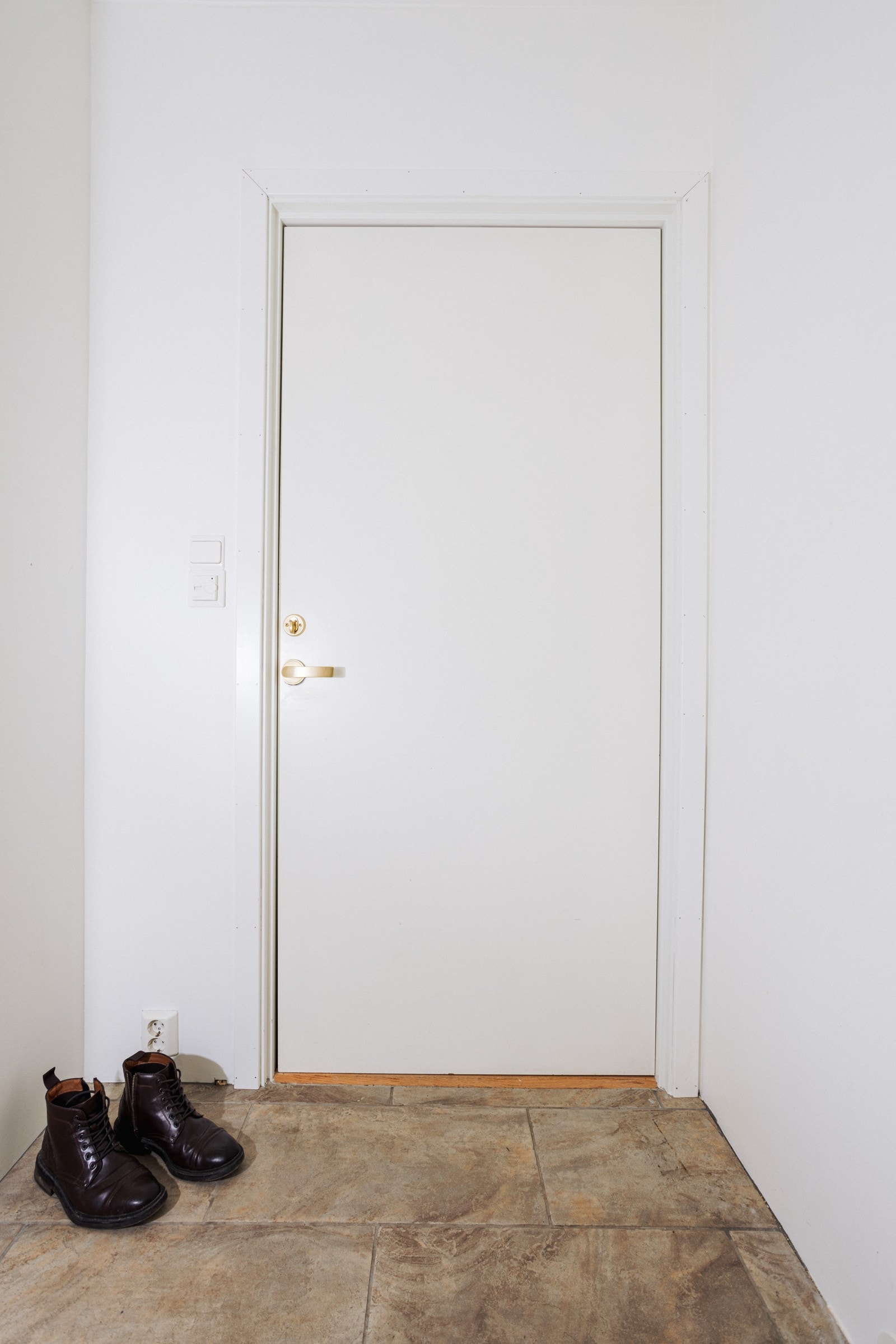 Lys og romslig entrè med hvitmalte vegger og fliser på gulv. Galleribilde