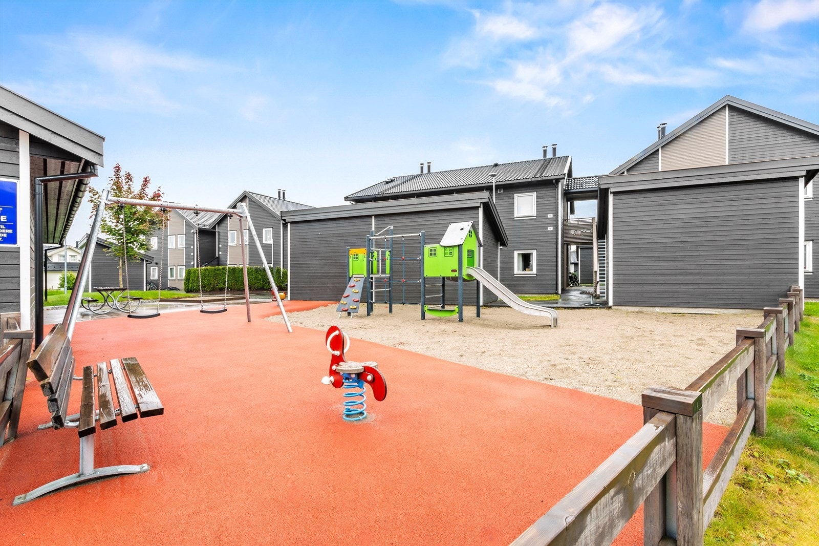 I umiddelbar nærhet er det et hyggelig, inngjerdet fellesområde med huskestativ, sittebenker og plenareal. Galleribilde