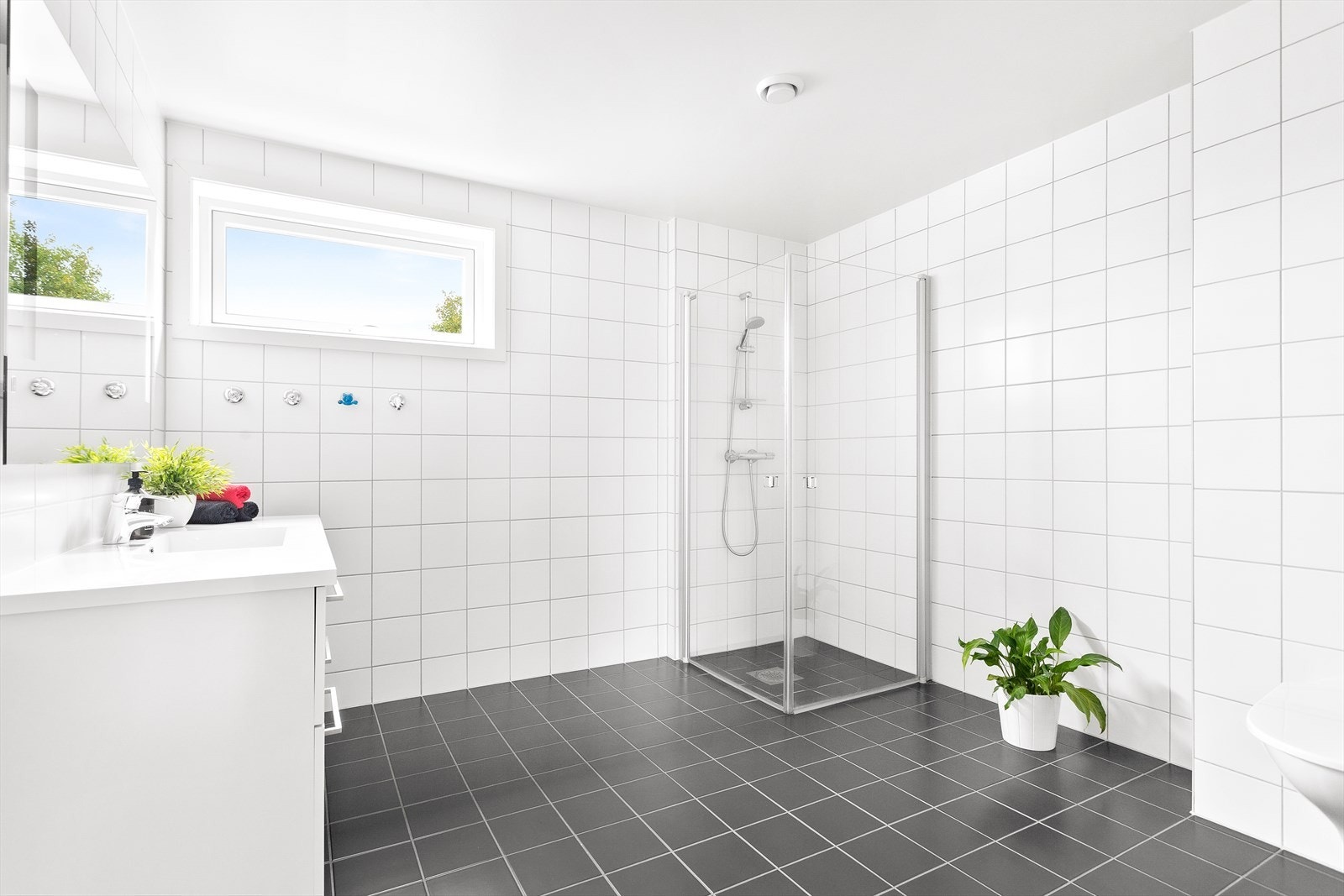 Begge badene er utstyrt med vegghengt toalett, dusjhjørne med innfellbare, rette glassdører og vegghengt baderomsinnredning. Galleribilde