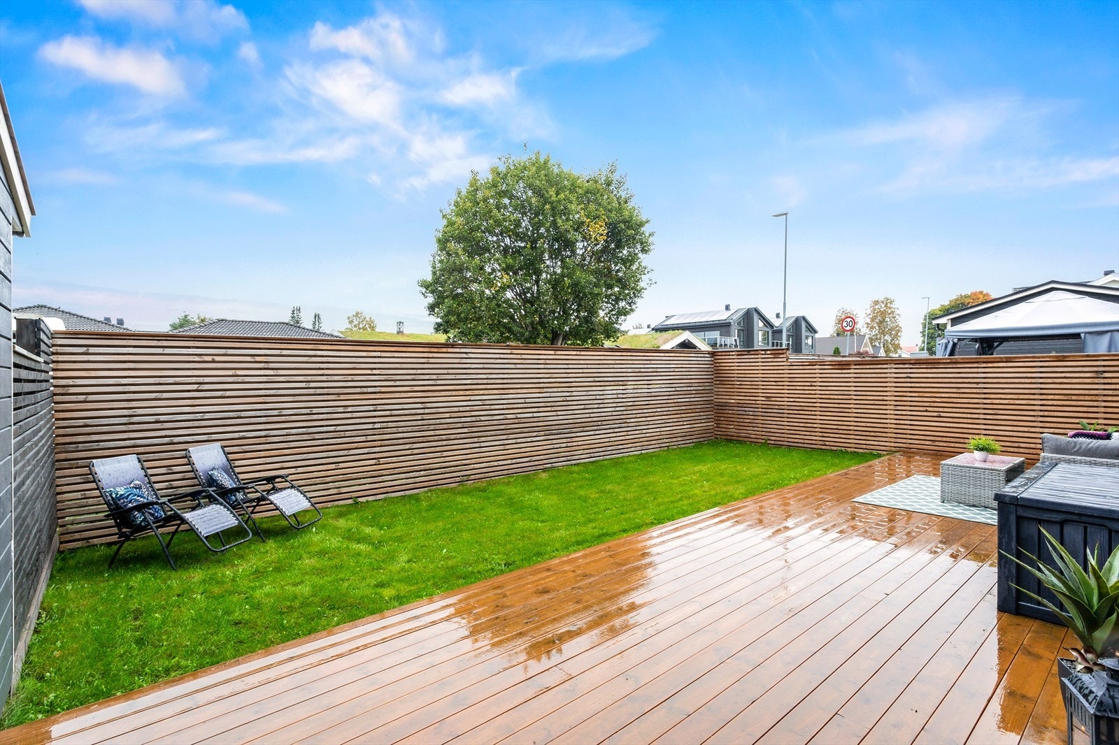 Hagen er inngjerdet av høye levegger med liggende spiler - her kan barn og firbente leke i trygge omgivelser. Galleribilde