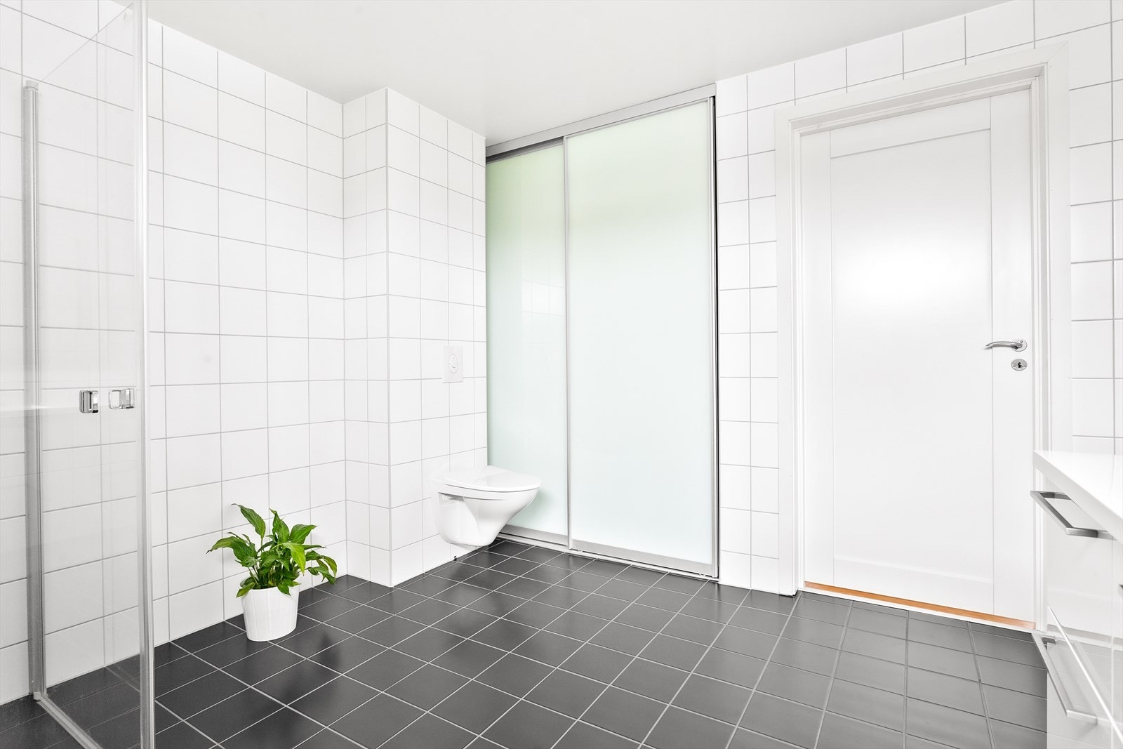 Badet i andre etasje har en skjult vaskeromsdel bak skyvedører med farget glass. Galleribilde