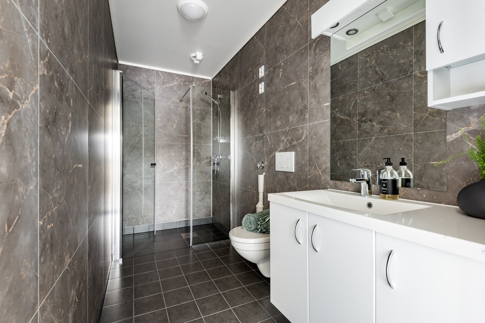 Badet i 1.etasje. Lekkert bad med toalett, servant og dusj. Bilete frå Strandhus 2 Galleribilde