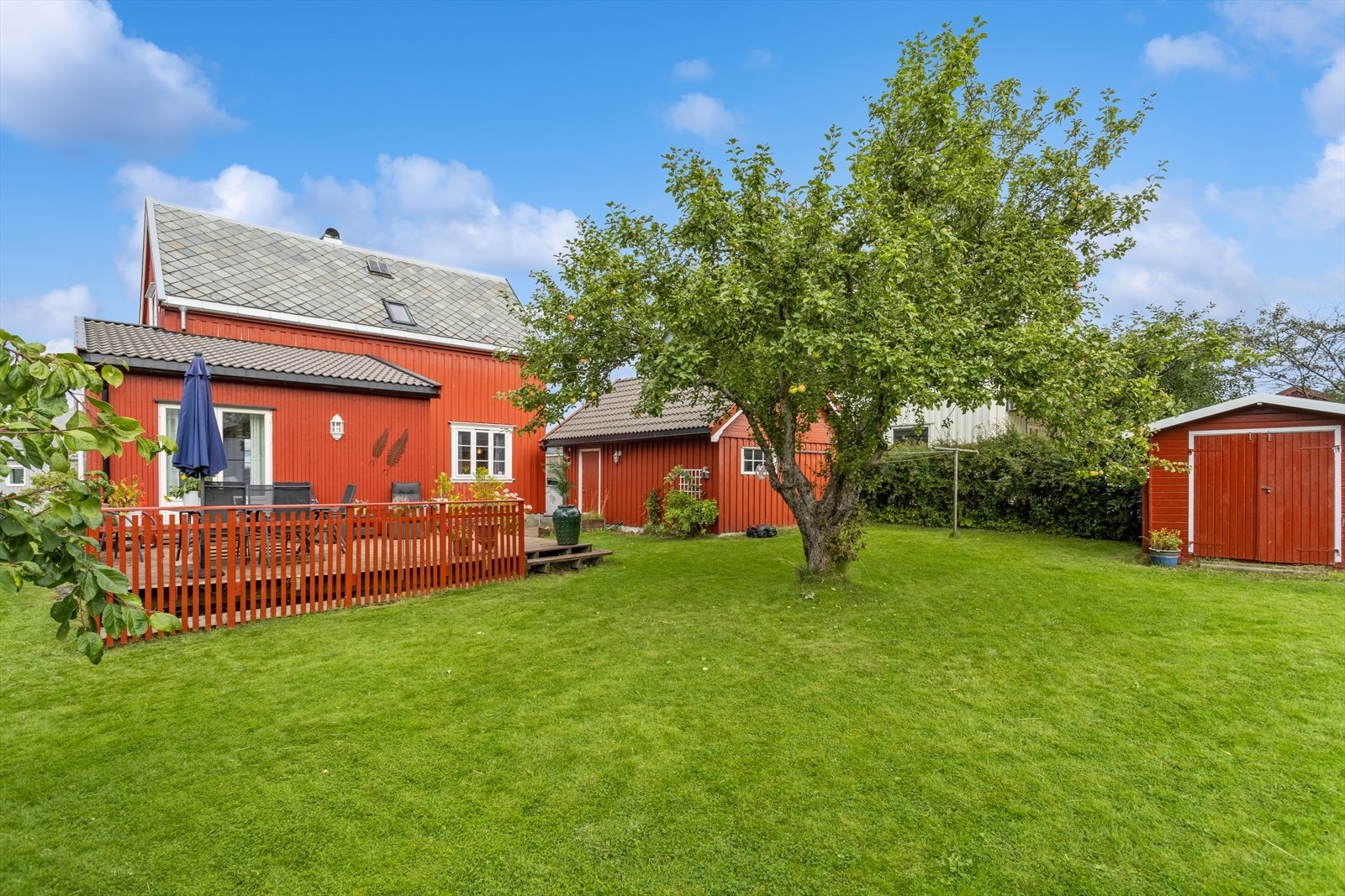 På tomta er godt med boltreplass til barna - her står det i tillegg en redskaps/vedbod. Galleribilde