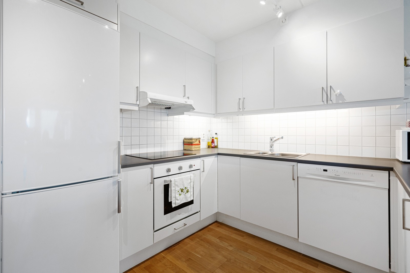 Innredningen har glatte fronter og laminat benkeplater med nedfelt rustfri oppvaskkum og tilhørende ett-greps blandebatteri. Galleribilde
