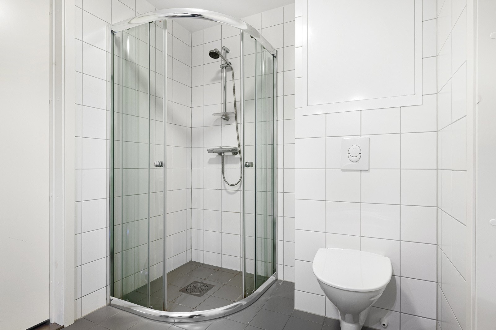 På badet er det gulvvarme, vegghengt toalett og et dusjhjørne med skyvedører. Galleribilde