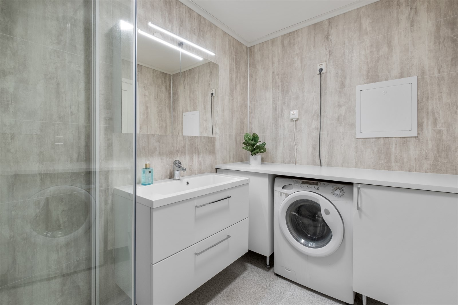 Benk og opplegg til vaskemaskin på badet Galleribilde