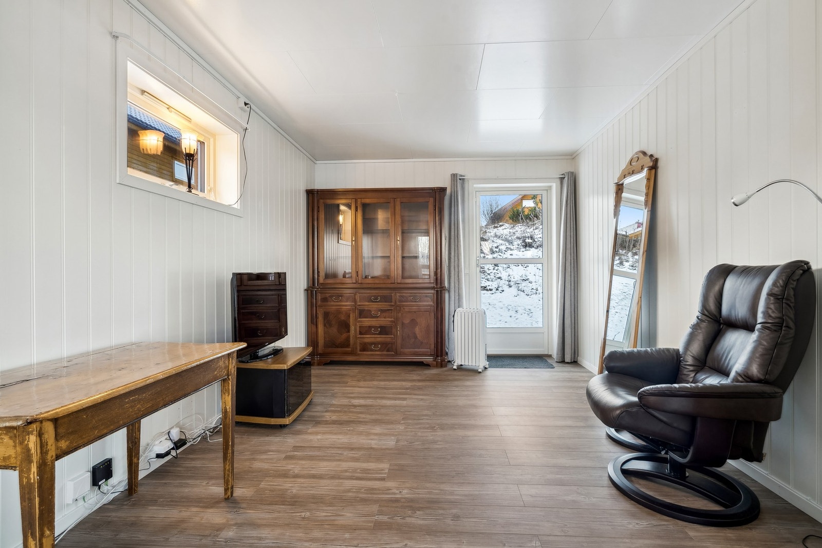 Stue med direkte utgang til markterrasse på baksiden av boligen. Galleribilde