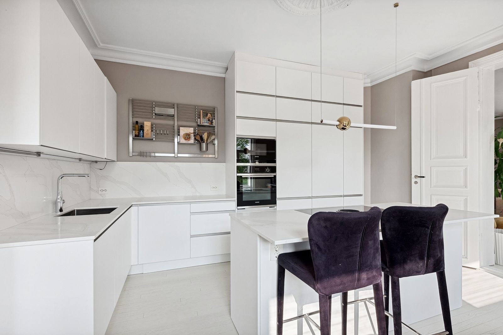 Kjøkken med lyse fronter og benkplate av stein. Galleribilde