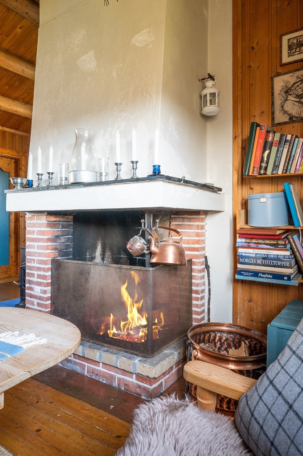 Plassbygget åpen peis av teglstein, og vedovn tilkoblet i stuen for de kaldere dagene Galleribilde