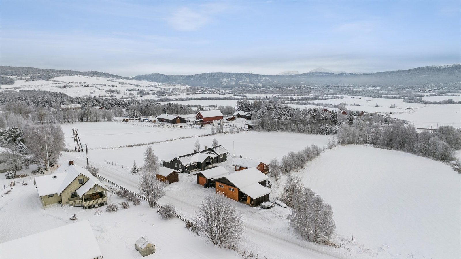 Utsikt mot bygda, sentrum og med fjellene i bakgrunnen. Galleribilde