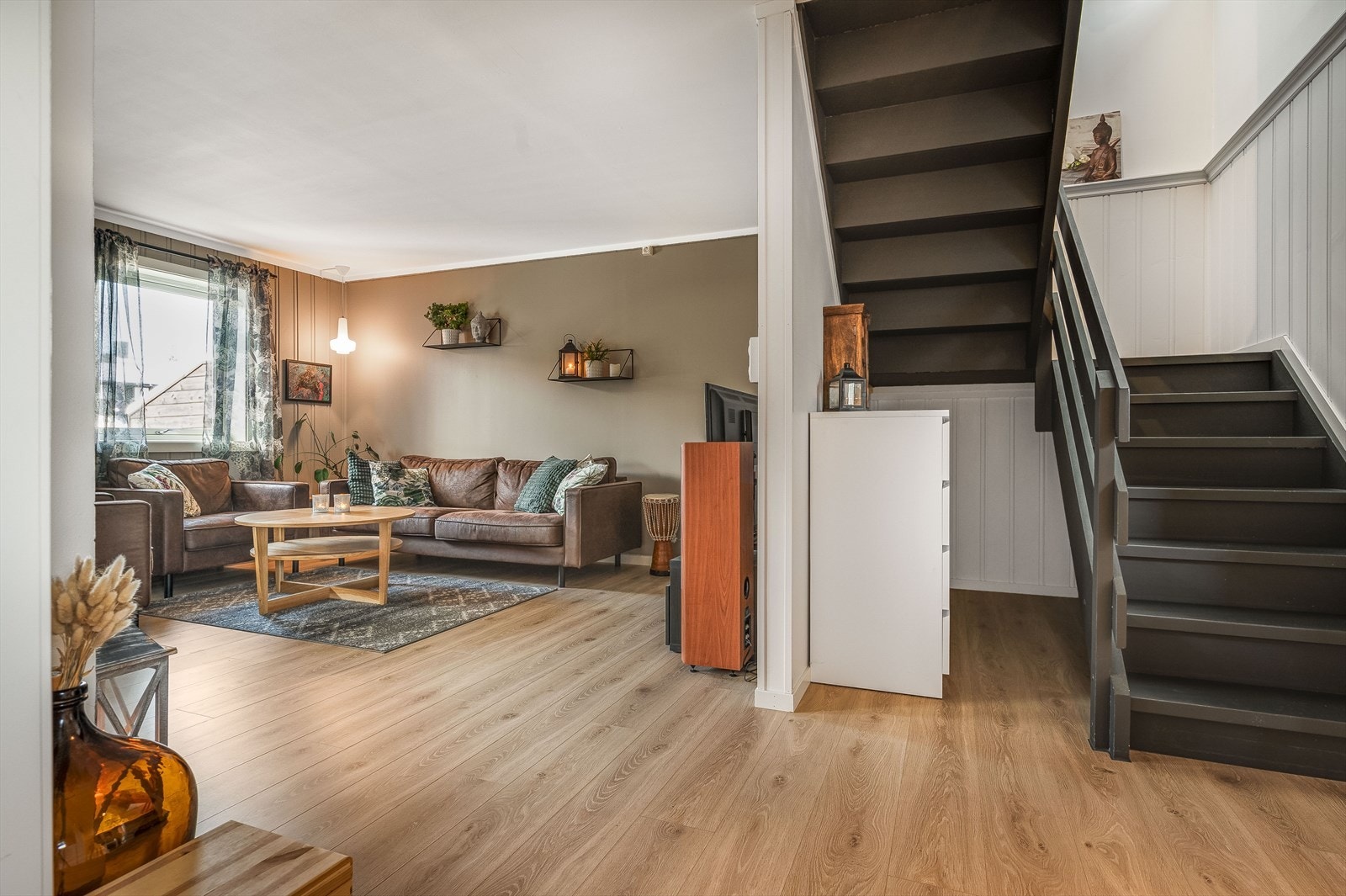 Høytrykkslaminatgulv, samt malte vegger i lune fargetoner er gjennomgående i hele leiligheten. Trappen er mørkmalt. Galleribilde