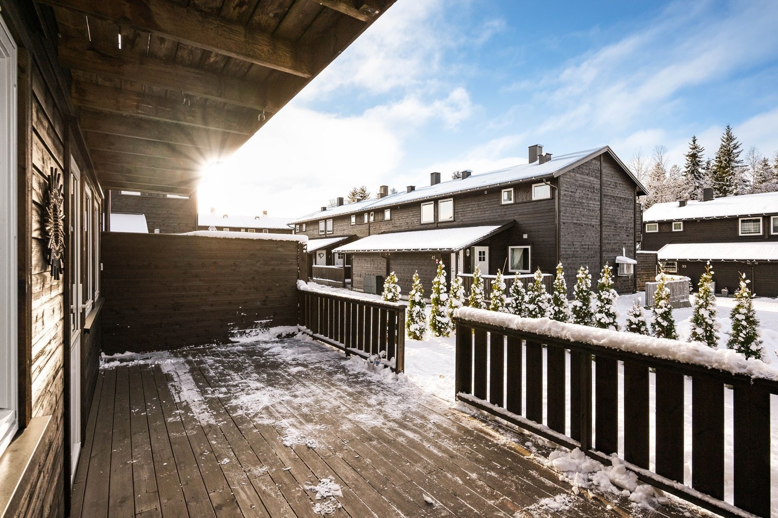 Terrassen har rekkverk og levegger mot naboer. Trapp ned til hageflekk som er innhegnet med hekk. Galleribilde