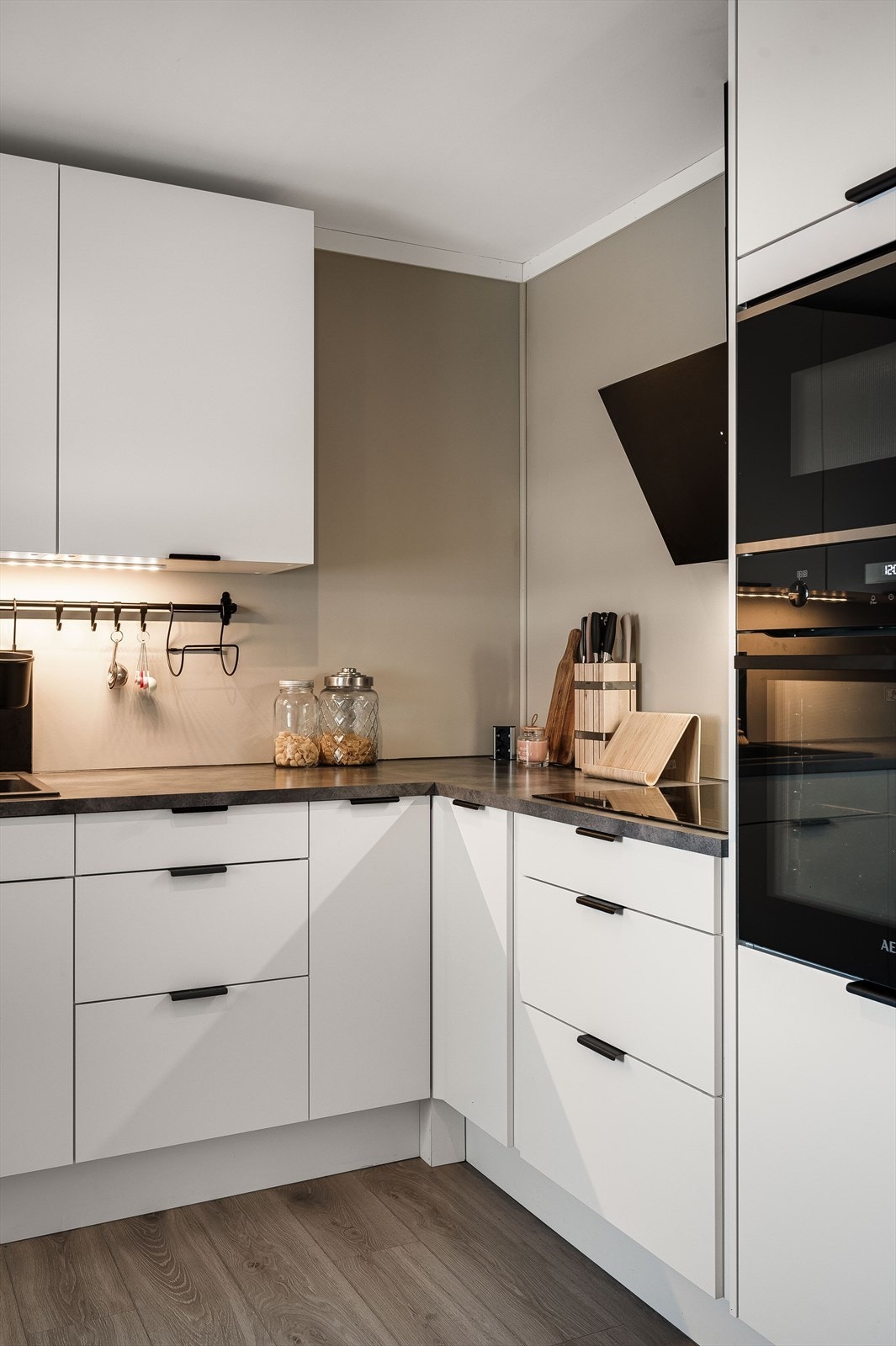 Integrerte hvitevarer i form av micro, oppvaskmaskin, stekeovn og koketopp med ventilator over. Galleribilde