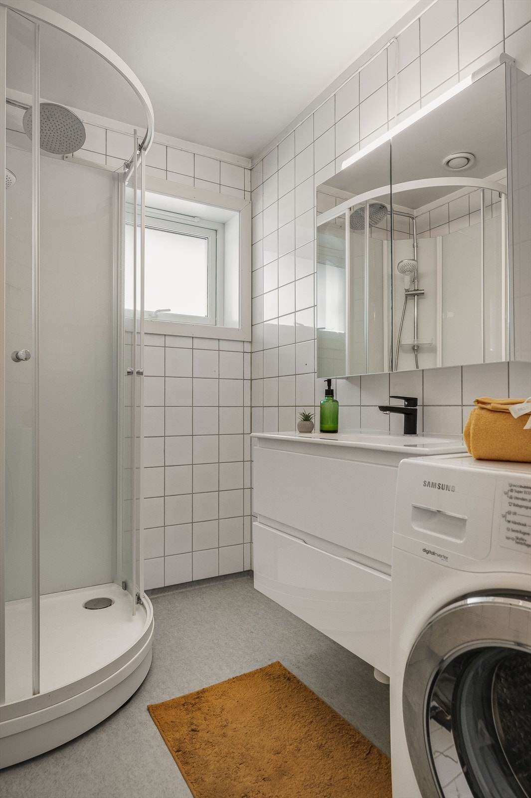 Ny baderomsinnredning fra 2023 med servant på underskap og speilskap med belysning over. Galleribilde