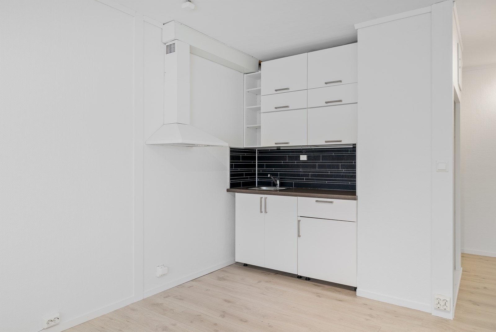Innredning med glatte fronter og laminert benkeplate med nedfelt oppvaskkum.
Vannfast plate på vegg mellom benk og overskap Galleribilde