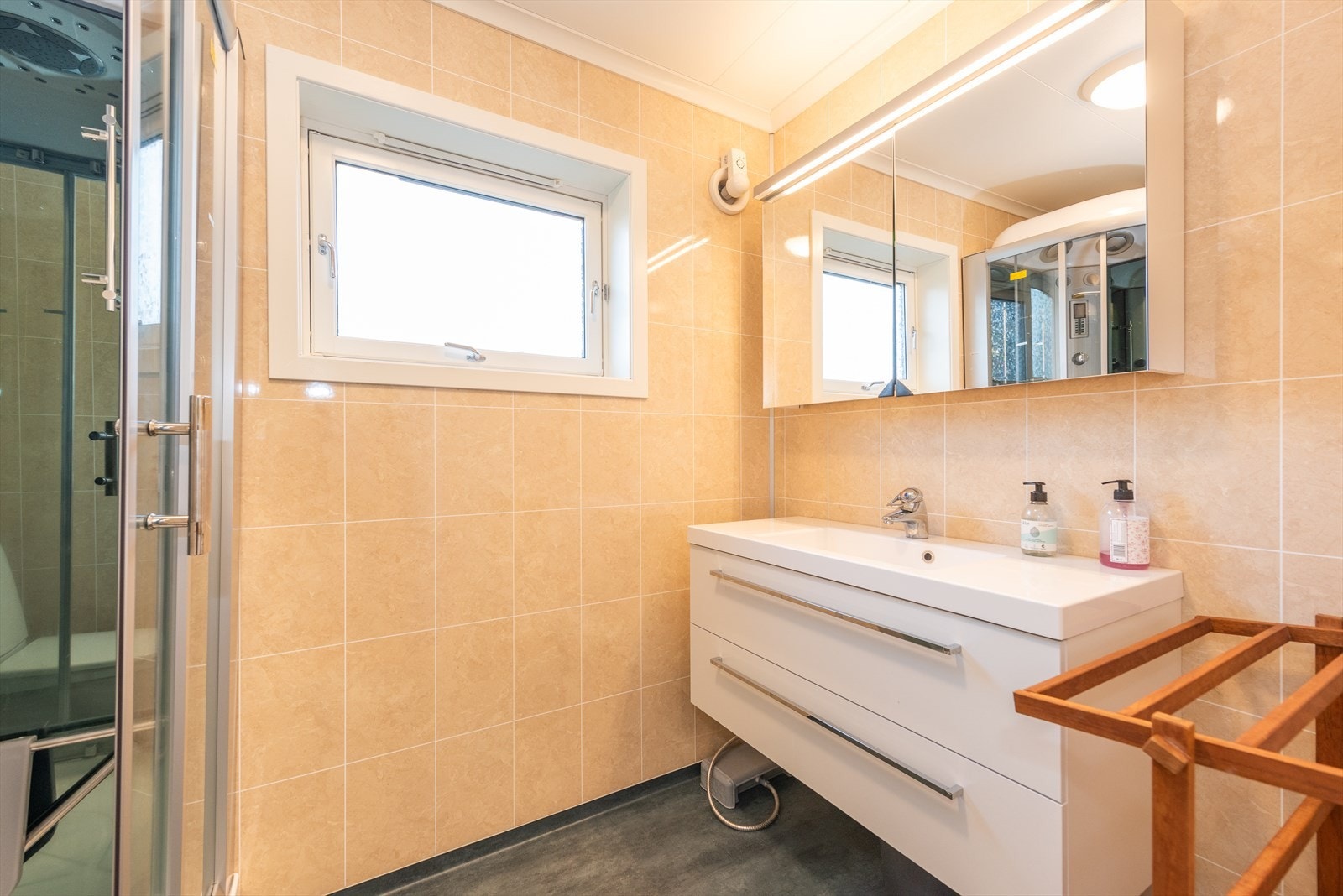Badet er av god størrelse og er innredet med toalett, dusjkabinett og innredning med speil. Galleribilde