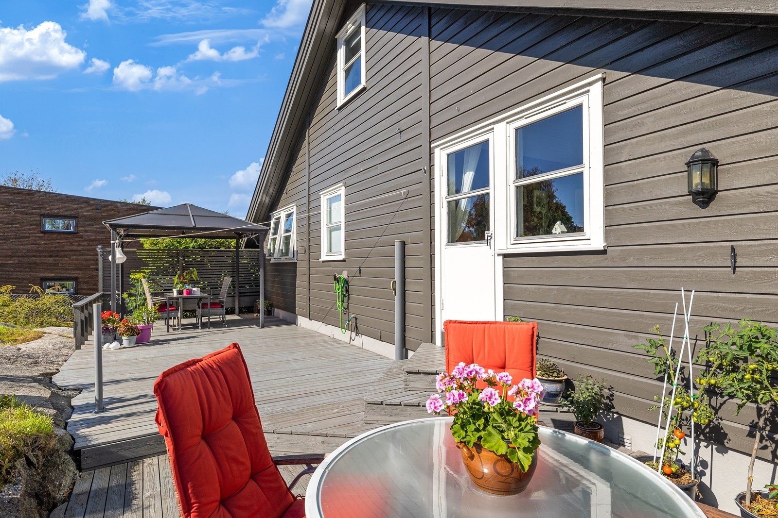 Unik terrasse som bør oppleves. Den fremstår som en nydelig oase. Dette er virkelig en plass man kan sitte å nyte både blomster, stemning og sol. Galleribilde