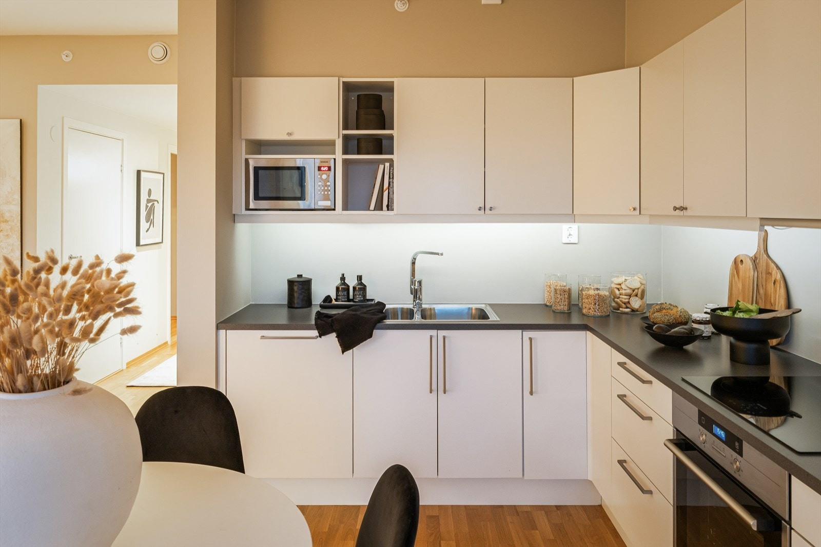 Leiligheten byr på et moderne kjøkken på 9m² med slette fronter og integrerte hvitevarer. Galleribilde