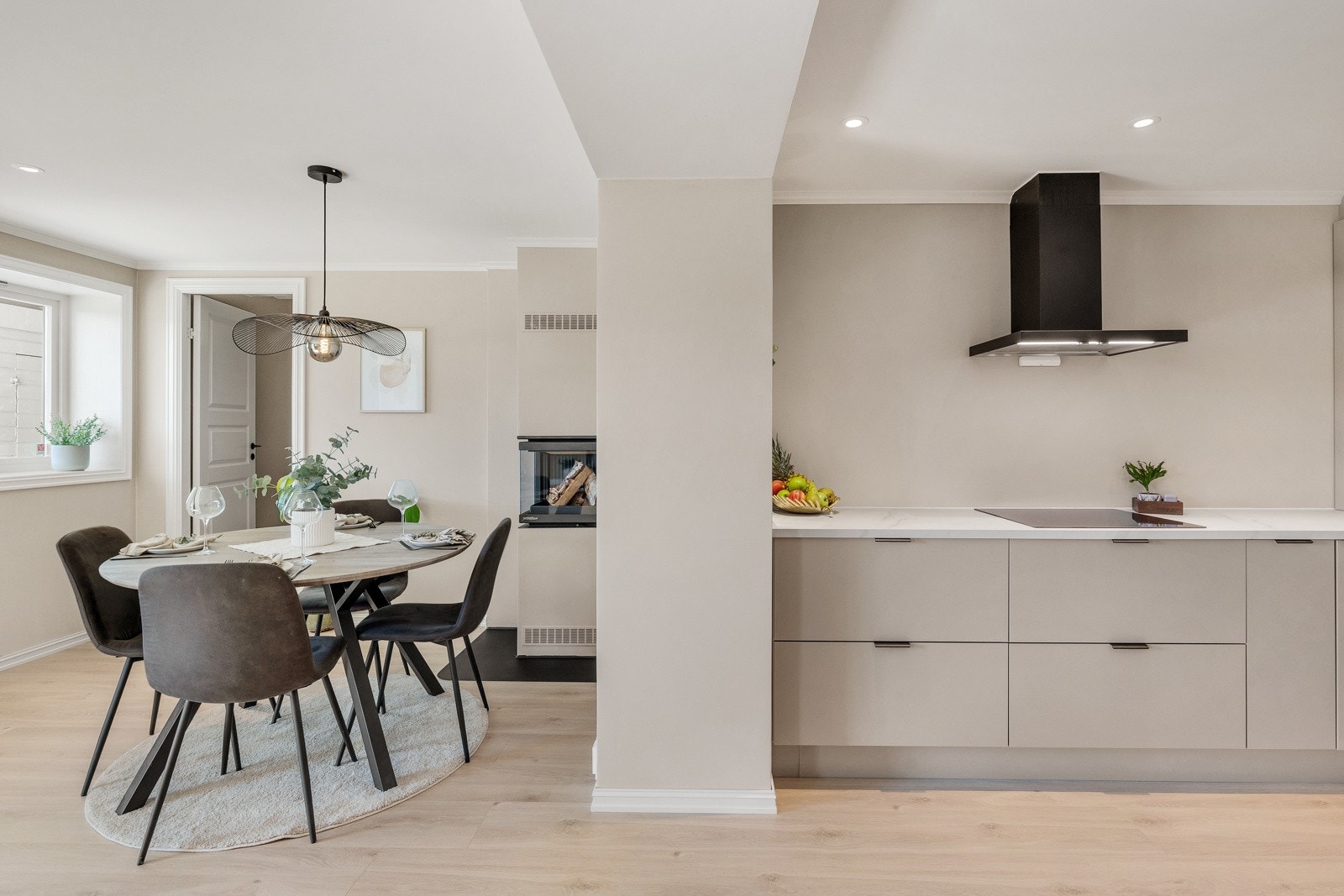 Moderne kjøkken i stilren utførelse som ligger i en smart, sosial og åpen løsning mot stuen. Galleribilde