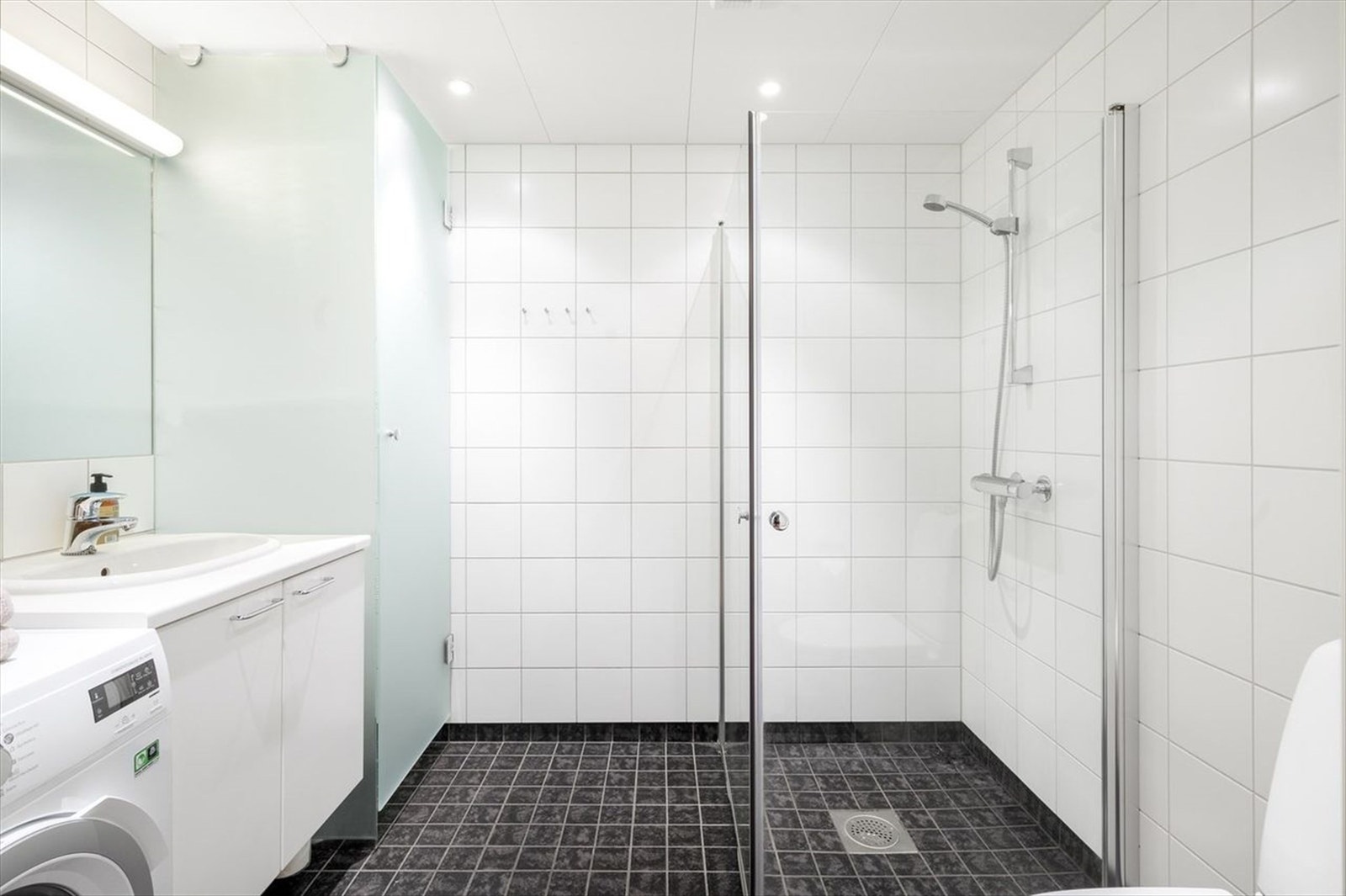 Delikat baderom med plass til vaskemaskin. Galleribilde
