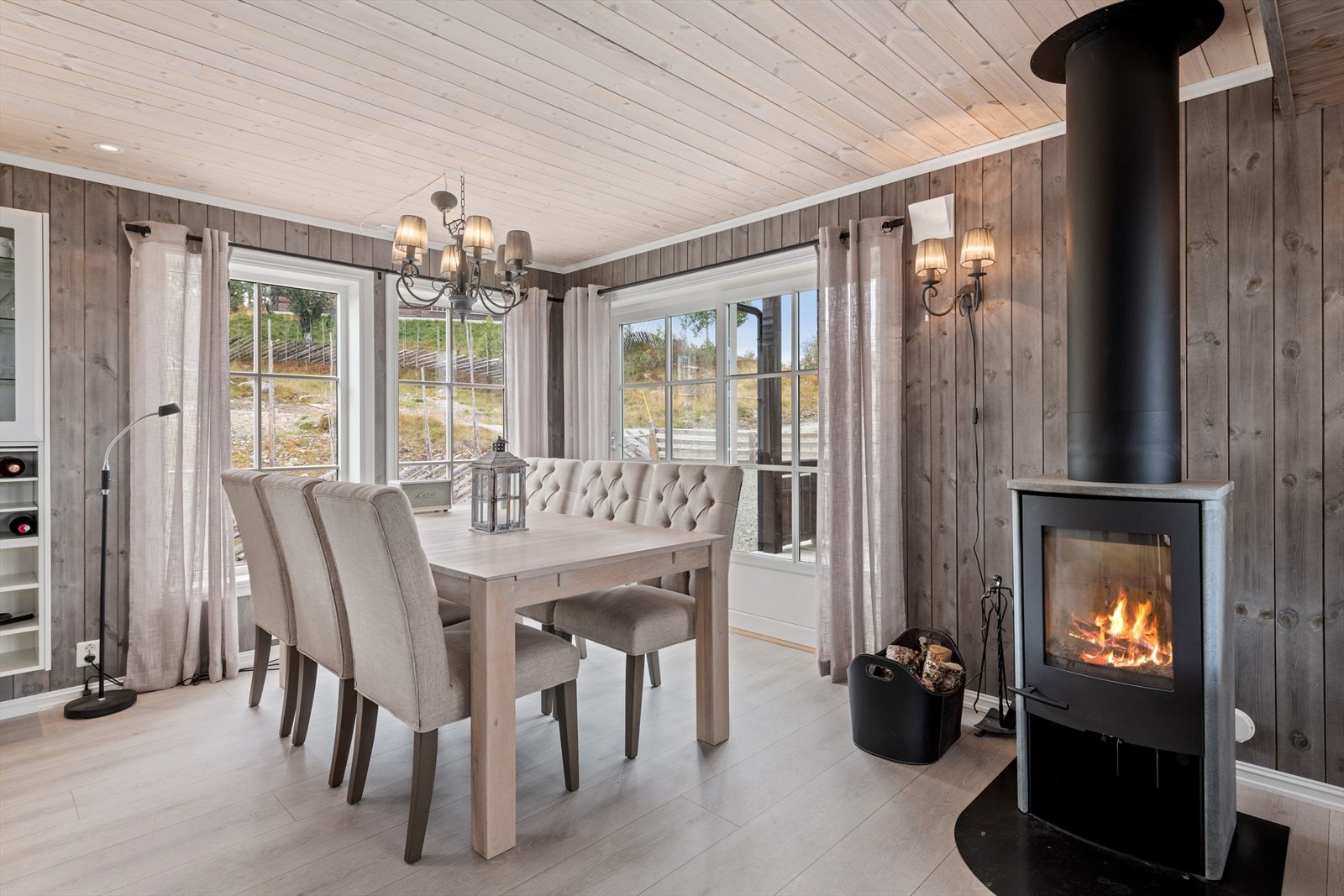 En moderne peisovn kledd med kleberstein for kos og varme. Utgang til en delvis overbygget terrasse. Galleribilde