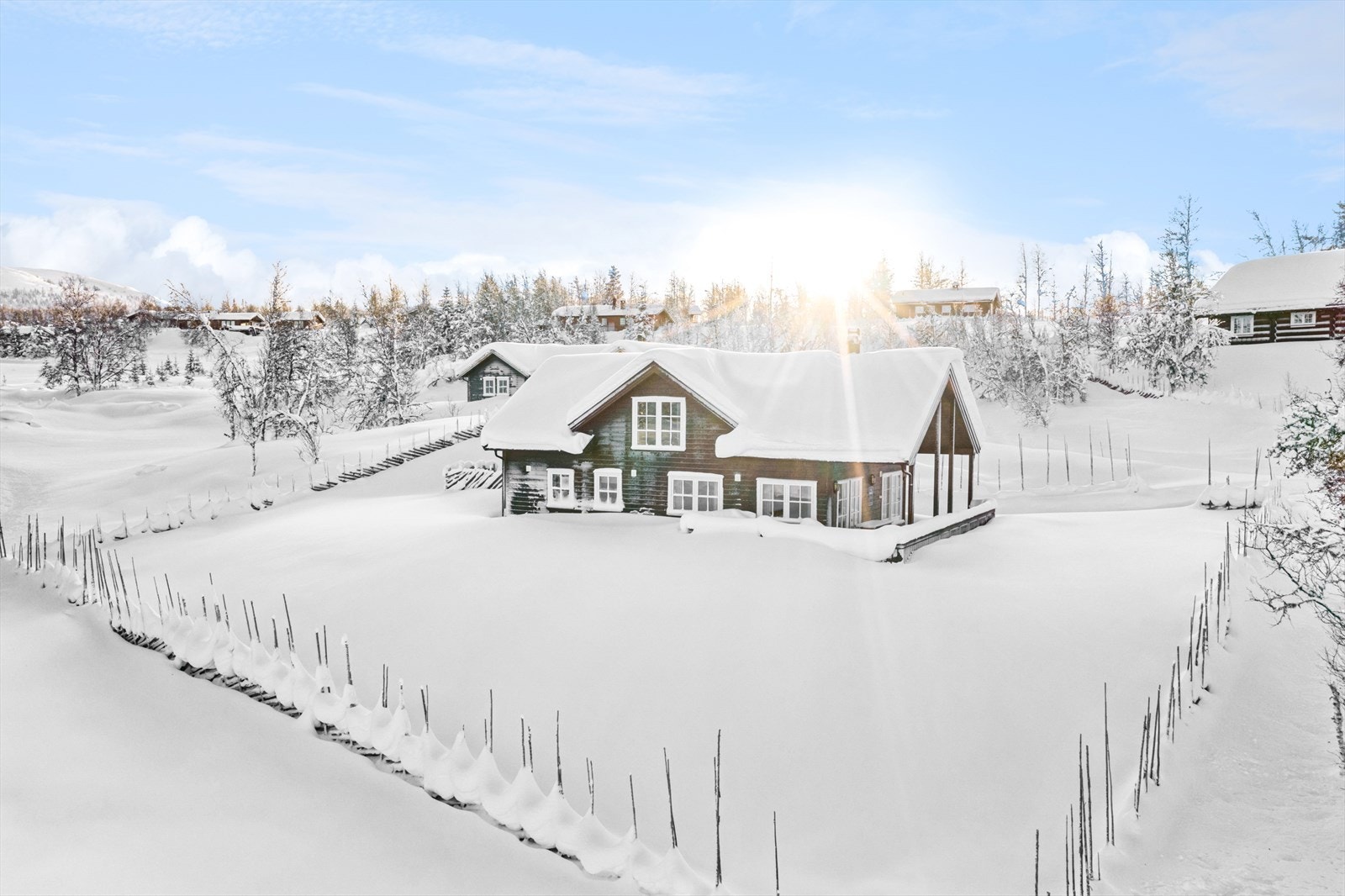 Rundt hytta er det satt opp skigard, og det er god plass for parkering for flere biler på gårdsplassen Galleribilde