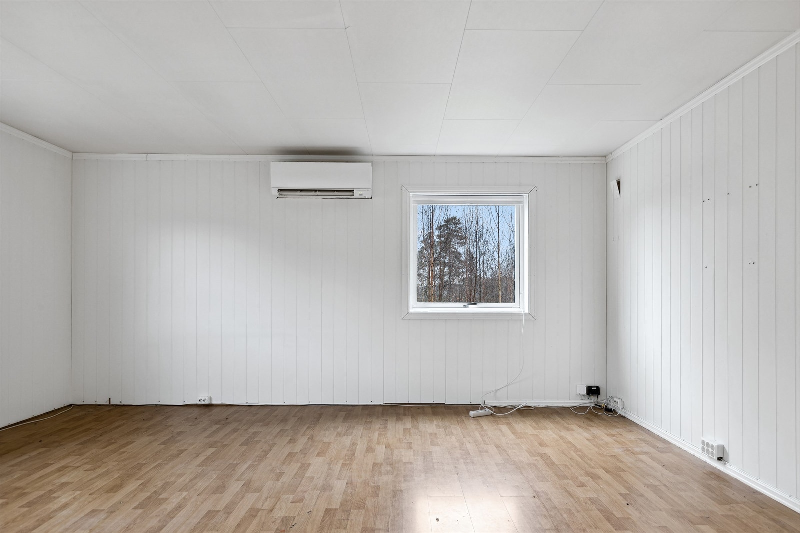 Stuen har hvitmalt panelplater på veggene og laminat på veggene. Galleribilde
