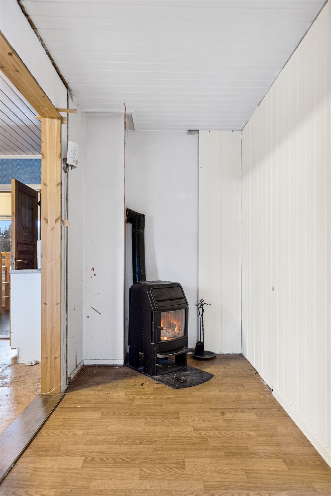 I gangen mellom stuen og kjøkkenet er det etablert en vedovn, som gir godt med varme. Det er åpen løsning mellom gangen og stuen. Galleribilde