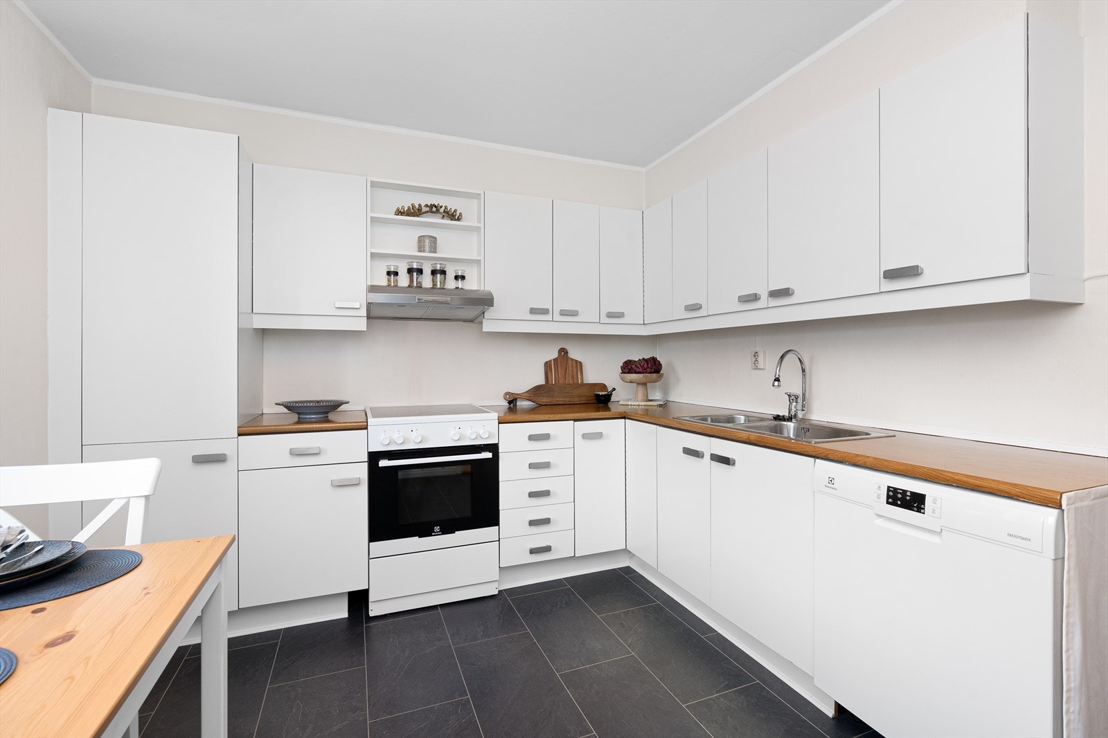 Her har du rikelig med oppbevaring i overskapene, samt at du har plass til et mindre spisebord med stoler. På gulvet er det belegg, samt malte overflater. Galleribilde